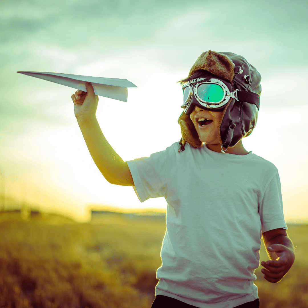 a young person wearing goggles and holding a paper airplane