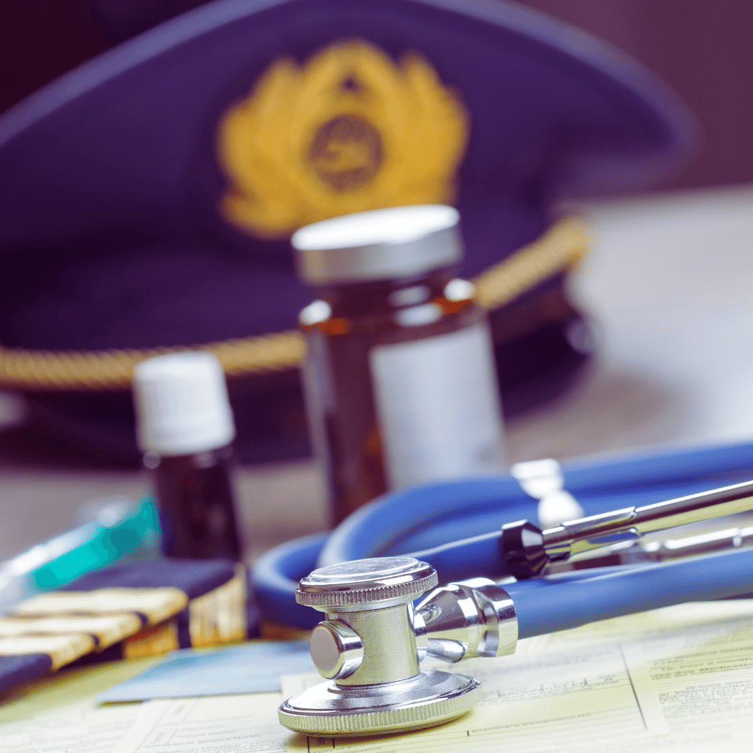 a stethoscope and other medical supplies on a desk in front of a pilot's hat